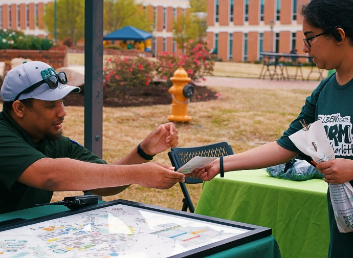 Two people are exchanging flyers at an event.